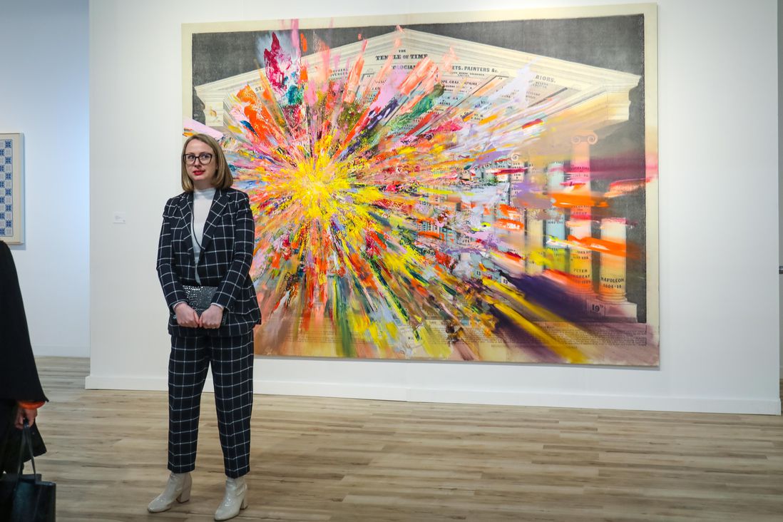 woman standing in front of colorful abstract painting